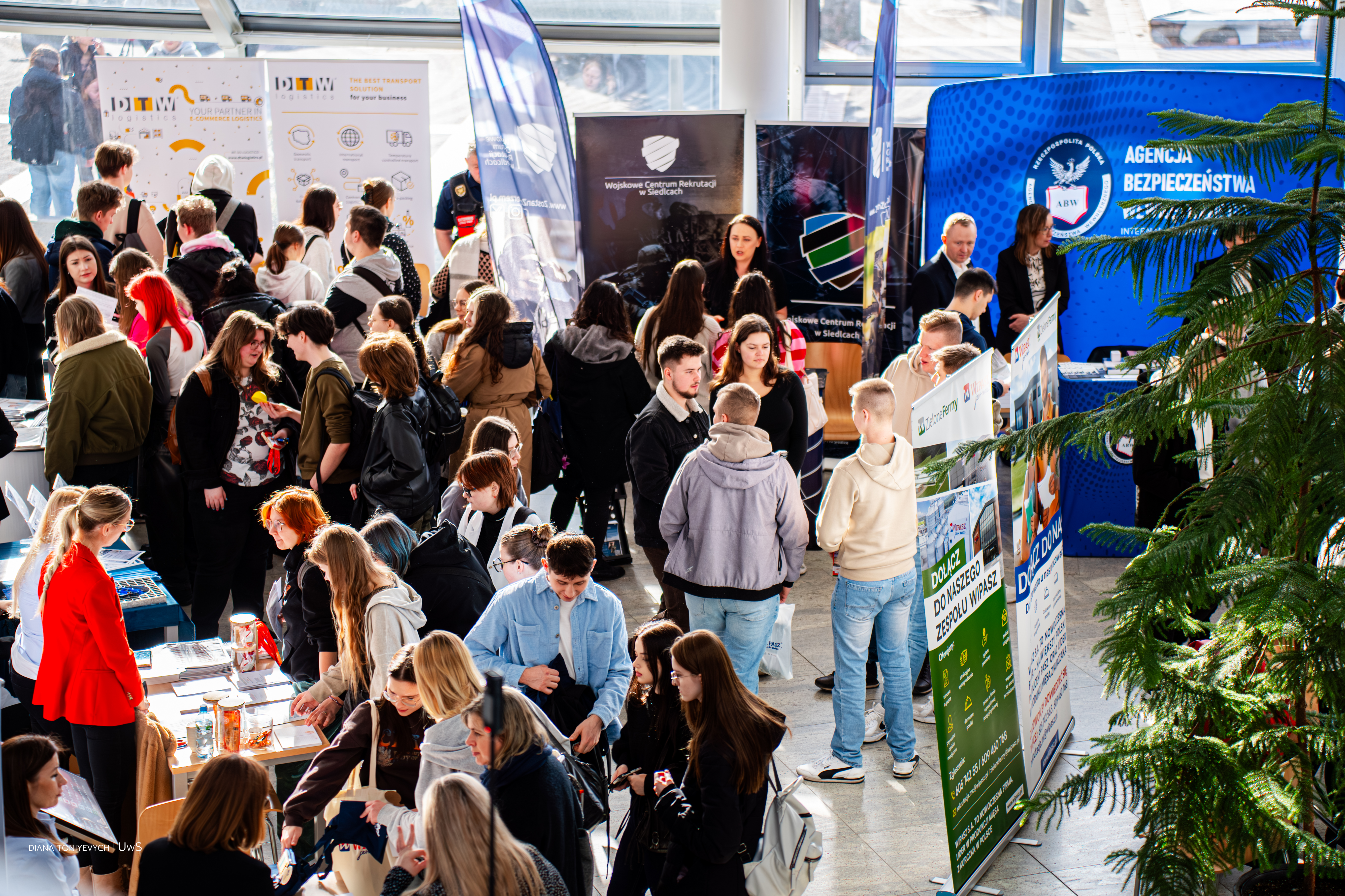 Studenci i wystawcy tłumnie biorą udział w giełdzie. Studenci podchodzą do stoisk na korytarzu wydziału Społecznego UwS.