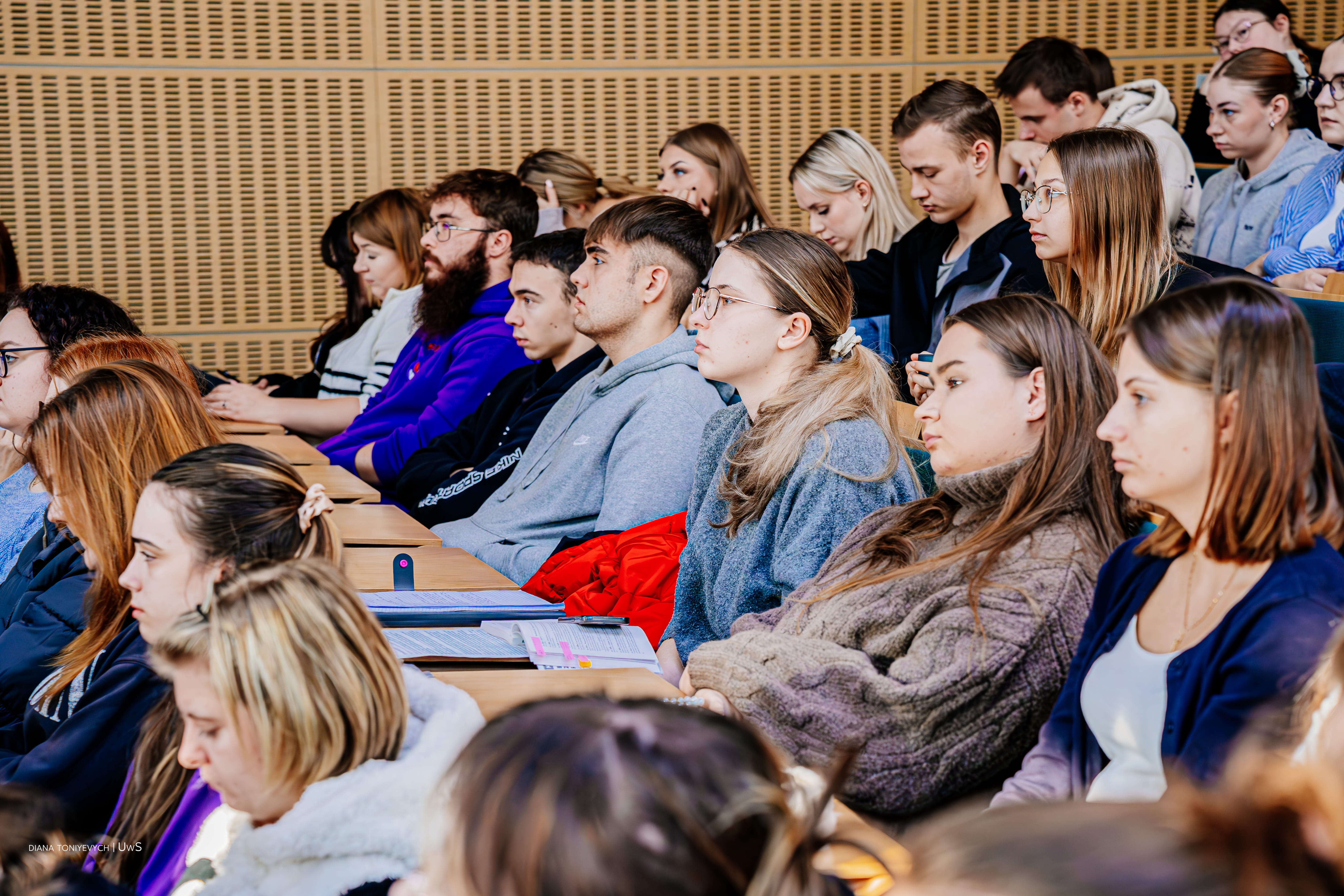 Ludzie siedzą na webinarze w auli.