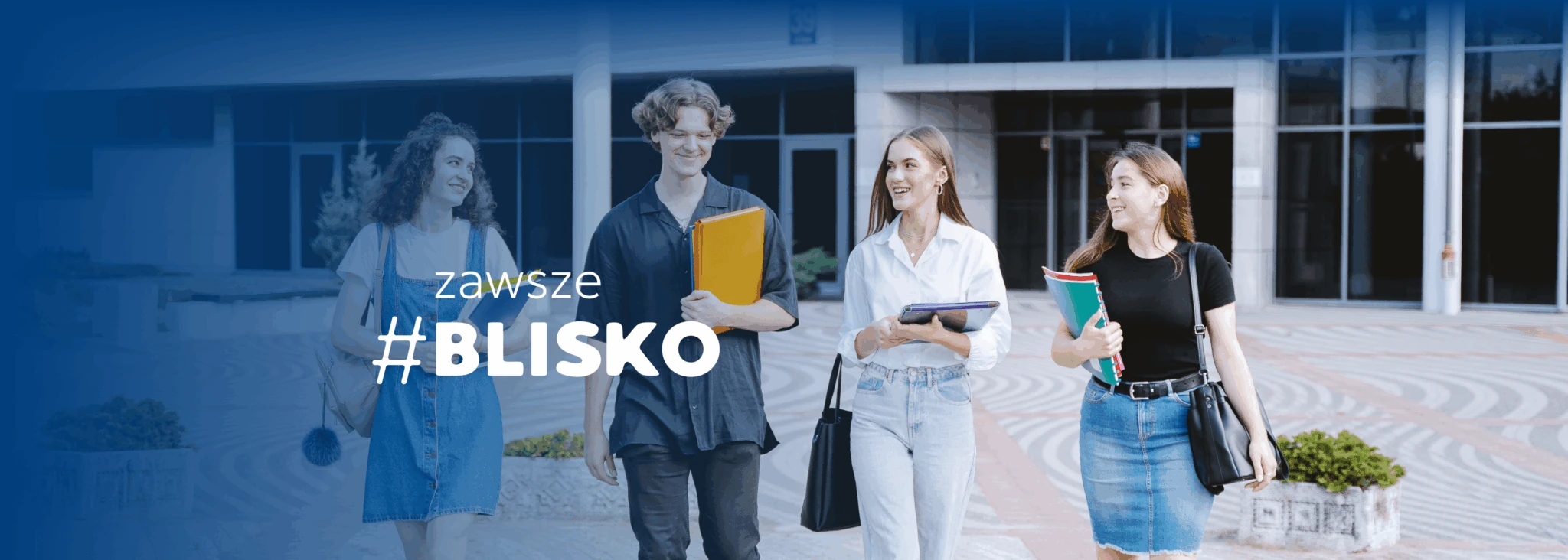 Studenci przechadzają się po kampusie UwS. NA banerze widać napis #zawszeBLISKO